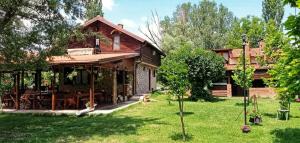 a log cabin with a table and chairs in a yard at Selsko domacinstvo Nevena in Kumanovo