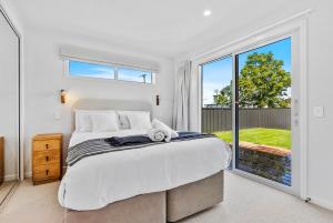 a bedroom with a large bed and a large window at Renovation, location, relaxation in Twizel