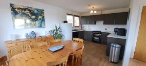 a kitchen with a wooden table and a dining room at Solheim Self Catering in Whiteness