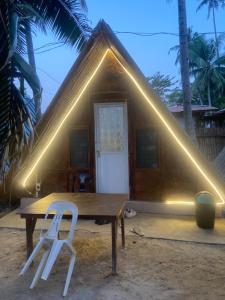 a table and two white chairs in front of a house at Sea Breeze Lodge in Siquijor