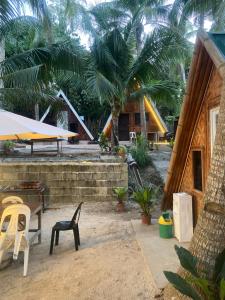 a patio with chairs and a house with palm trees at Sea Breeze Lodge in Siquijor