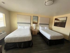 a hotel room with two beds and a window at Citrus Inn & Suites in Porterville