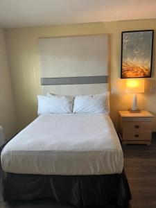 a bedroom with a large bed with white sheets and pillows at Citrus Inn & Suites in Porterville +2 photos