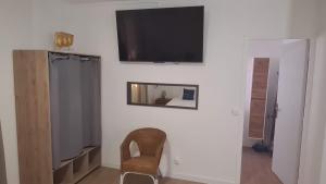 a room with a television on a wall with a chair at Paradies Caraibes IV in Les Abymes