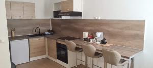 a kitchen with a wooden counter and chairs in it at Paradies Caraibes IV in Les Abymes
