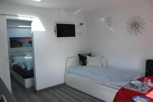 a bedroom with a bed and a tv on the wall at Alojamentos Céu Azul in Fernao Ferro