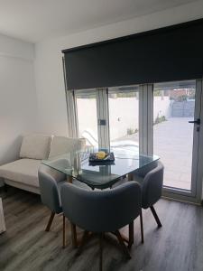 a living room with a glass table and chairs at Alojamentos Céu Azul in Fernao Ferro