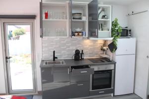 a kitchen with a sink and a refrigerator at Alojamentos Céu Azul in Fernao Ferro