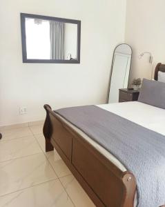 a bedroom with a bed with a mirror on the wall at Durban Oceanic Apartment 82B in Durban