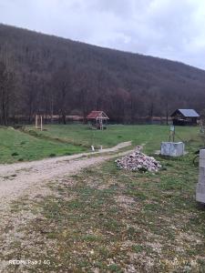 a dirt road in a field with a house in the background at Kamp Suad in Zaglavica