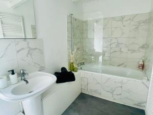 a white bathroom with a sink and a shower at Studio spacieux et calme - Parking facile in La Rochefoucauld