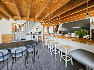 an open kitchen with a bar and stools at La Maison des Jeux in Saint-Maur