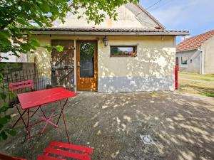 a red table and chairs in front of a house at La Maison des Jeux in Saint-Maur