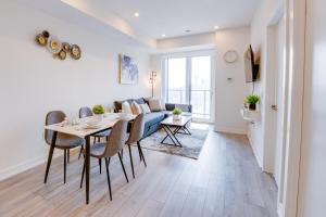 a dining room with a table and a couch at Stylish Open Concept Condo with Gym in Kitchener +39 photos
