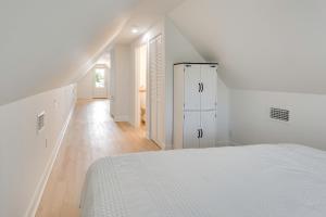 a white bedroom with a white bed and a hallway at Brand New Home in Steinhatchee with Rooftop Deck! in Jena