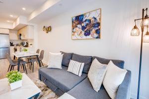 a living room with a blue couch and a kitchen at Stylish Open Concept Condo with Gym in Kitchener