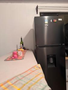 a black refrigerator in a kitchen with a table at Casa Malu in Morote