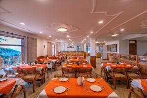 a restaurant with tables and chairs and a large window at PACK Shimla in Shimla