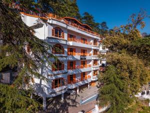 an apartment building in the middle of trees at PACK Shimla in Shimla