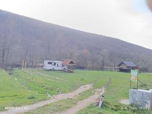 a rv parked in a field in front of a hill at Kamp Suad in Zaglavica
