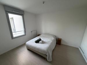a white room with a bed with a window at Appartement Sautron in Sautron