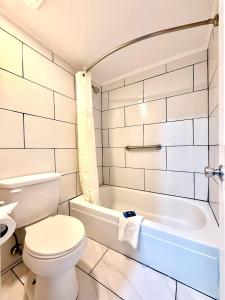 a bathroom with a toilet and a bath tub at Americas Best Value Inn Suites & Studios Blytheville by Sonesta in Blytheville