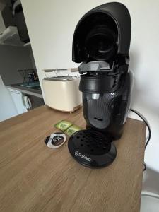 a black coffee maker sitting on top of a table at Appartement Sautron in Sautron