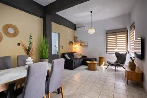 a living room with a table and chairs and a couch at El Dorado Corner with Hot Tub in Chania