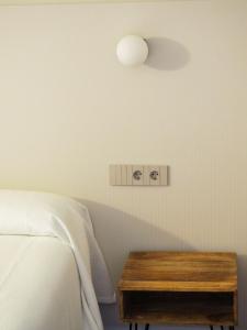 a bedroom with a bed and a wooden table at Hotel Tall de Conill in Capellades