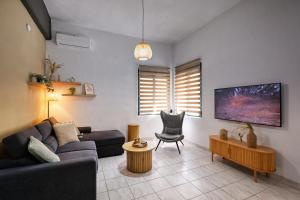 a living room with a couch and a chair at El Dorado Corner with Hot Tub in Chania