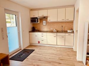 a kitchen with white cabinets and a kitchen rug at Ferienwohnung Moselverliebt in Schweich +20 photos