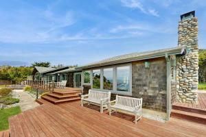 a wooden deck with benches on a house at Luxe Remodeled Oceanfront Home on the Bluff in Mendocino