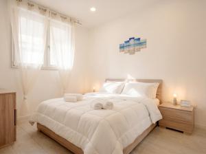 a bedroom with a large white bed with towels on it at SPA & RELAX Aesthetic Apartment 50m dal mare in Monopoli