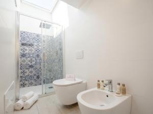 a white bathroom with a toilet and a sink at SPA & RELAX Aesthetic Apartment 50m dal mare in Monopoli