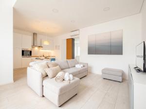 a white living room with a couch and a tv at SPA & RELAX Aesthetic Apartment 50m dal mare in Monopoli +13 photos