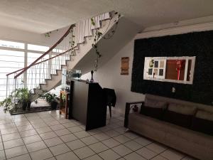 a living room with a staircase and a couch at Hostal menavi in León