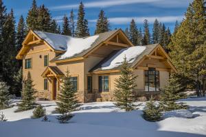 a house in the snow with snow at Creekside Chalet in Big Sky