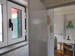 a bathroom with a window and a table and stool at Vila Real Center Terrace in Vila Real