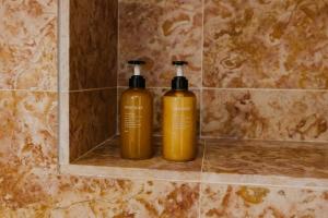 two gold bottles sitting on a shelf in a bathroom at Azenha da Duquesa in Sintra +28 photos