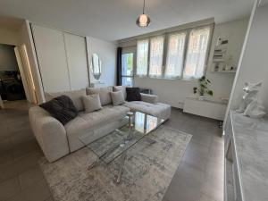 a living room with a couch and some windows at Le Contemporain in Troyes