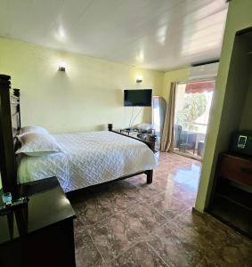 a hotel room with a bed and a television at Hotel La Llave del Mar Zona Colonial in Santo Domingo