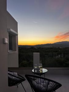 a balcony with two chairs and a table with wine glasses at Elaya Experience in Kamisianá