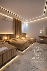 two beds in a hotel room with lights at شاليه هوانا in Sohar +126 photos