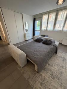 a bedroom with a large bed and a couch at Le Contemporain in Troyes