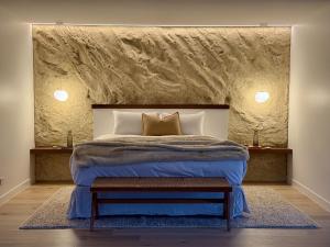 ein Schlafzimmer mit einem großen Bett und einer Steinwand in der Unterkunft Cedars Mount View (Adults Only) in Mount View
