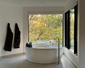 eine Badewanne in einem Zimmer mit einem großen Fenster in der Unterkunft Cedars Mount View (Adults Only) in Mount View