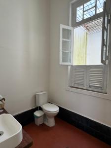 a bathroom with a white toilet and a window at Casa Igara Hostel in Belém