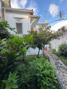 a white house with trees and plants in front of it at Casa Igara Hostel in Belém +35 photos