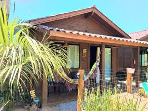 a house with a fence in front of it at Chalé piscina compartilhada com cozinha in Imbituba