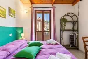 a bed with green and purple pillows in a room at Bed and Breakfast Cala Luna in Castelsardo